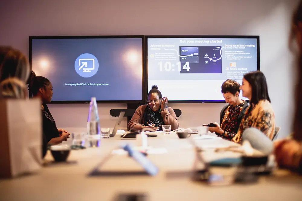 Women sit at a large table and work together.