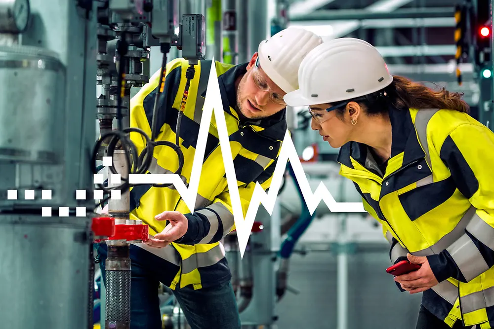 Two employees look at Loctite Pulse used on a step trap.